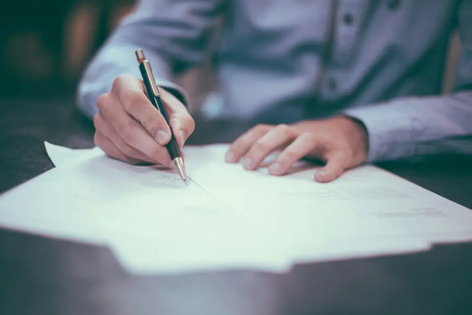 Auditor reviewing financial statements and signing documents