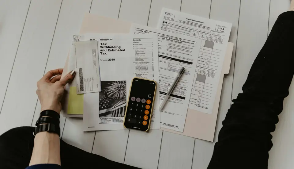 Accountant reviewing GST invoices and a calculator on a desk